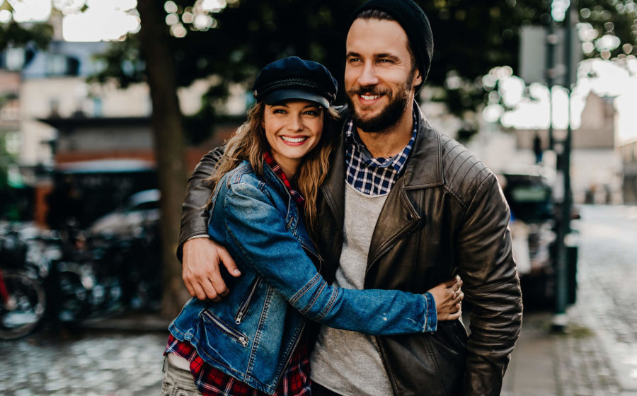 Happy young couple walking down street