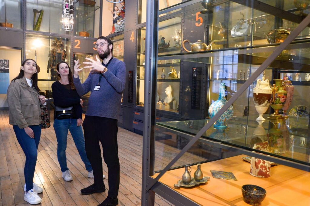 Discover Dublin's history, the tourguide shows two womwn some artefacts in a museum