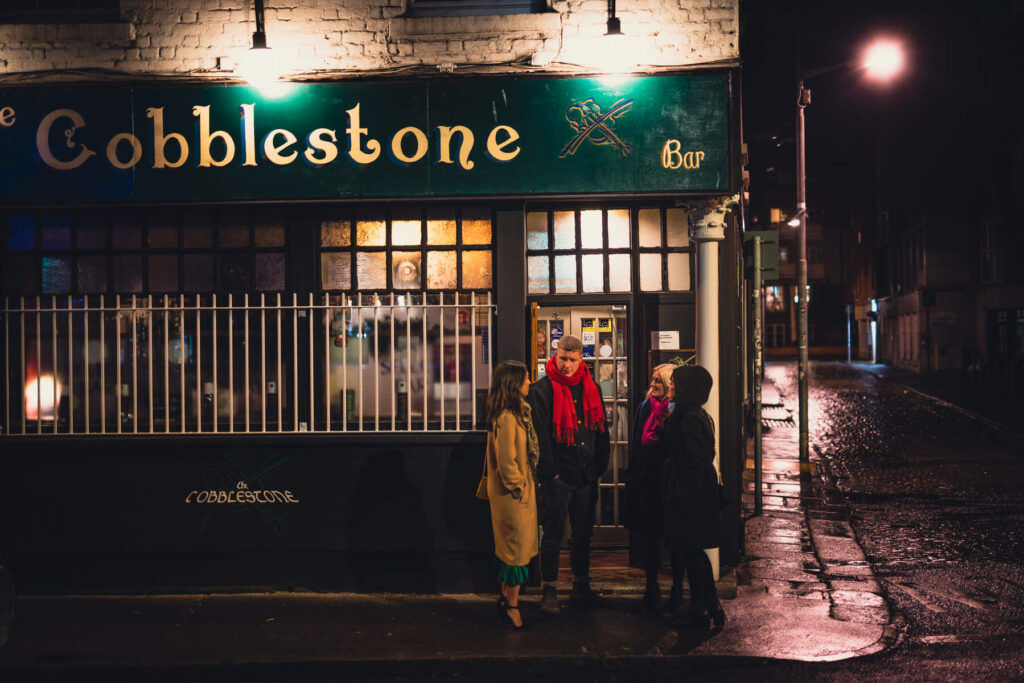 Exterior shot of Cobblestone pub, with two people outside the music Venue in Dublin