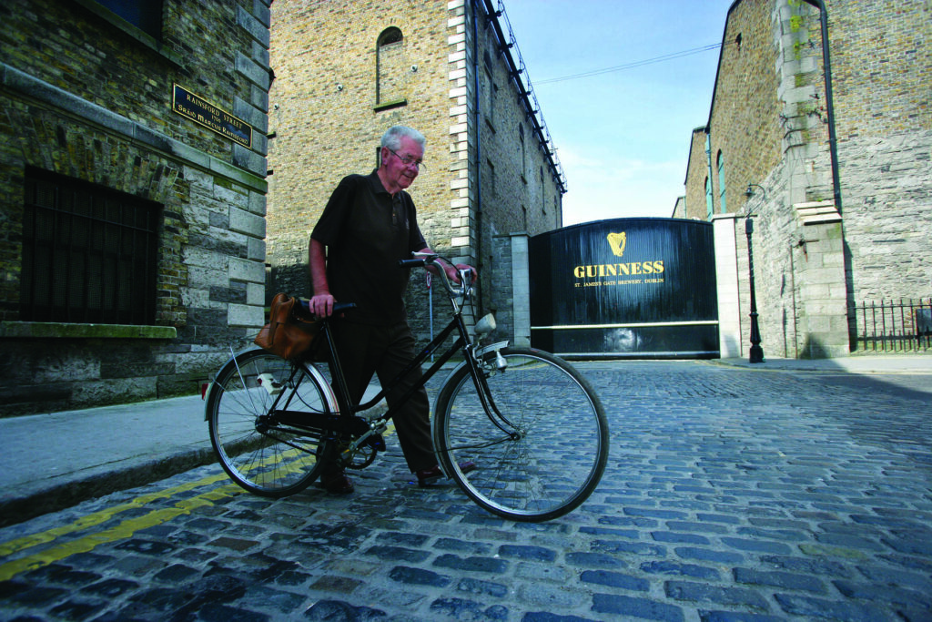 A man walks his bicycle past the Guiness Store House on Culture Night